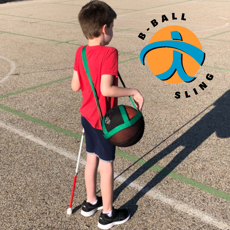 a boy on a playground wearing a b-ball sling that is holding a basketball